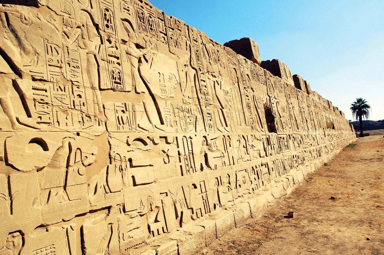 Ancient Egyptian hieroglyphs and art on a temple wall