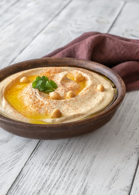 Bowl of creamy Hummus garnished with olive oil and parsley