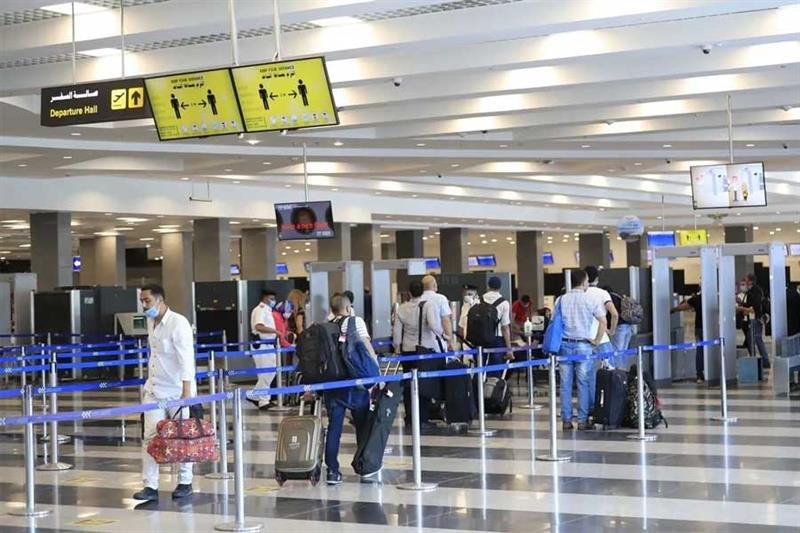 Travelers arriving at a bustling Egyptian airport terminal